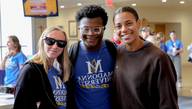 three students smiling in franciscan center